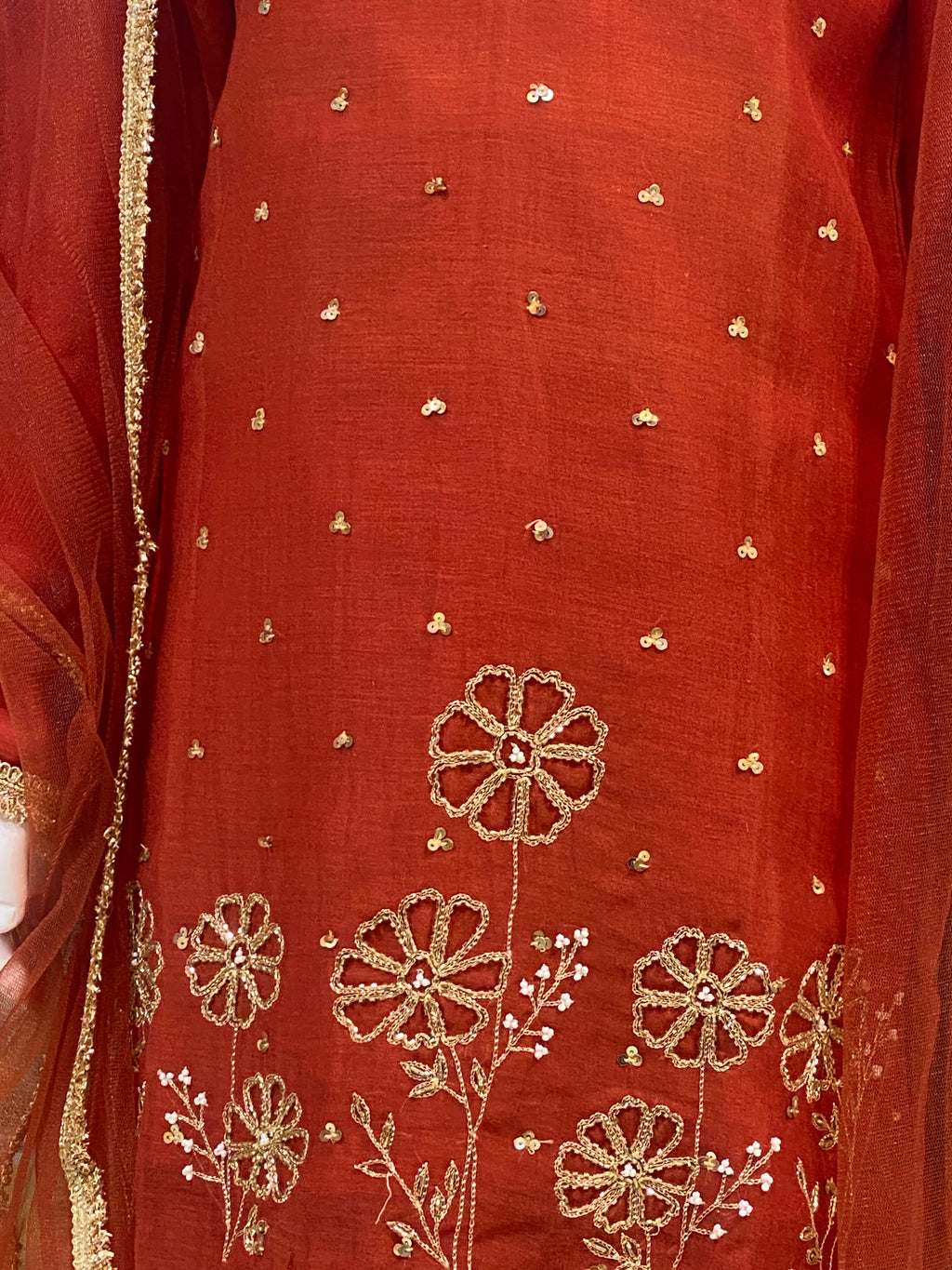 Girl wearing red floral embroidered lehenga set with V-neck kurta, flared lehenga and sheer gold-border dupatta