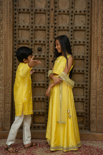 Yellow heart-themed boy kurta set and girl lehenga set by Marwar Roots, featuring vibrant traditional clothing for children.