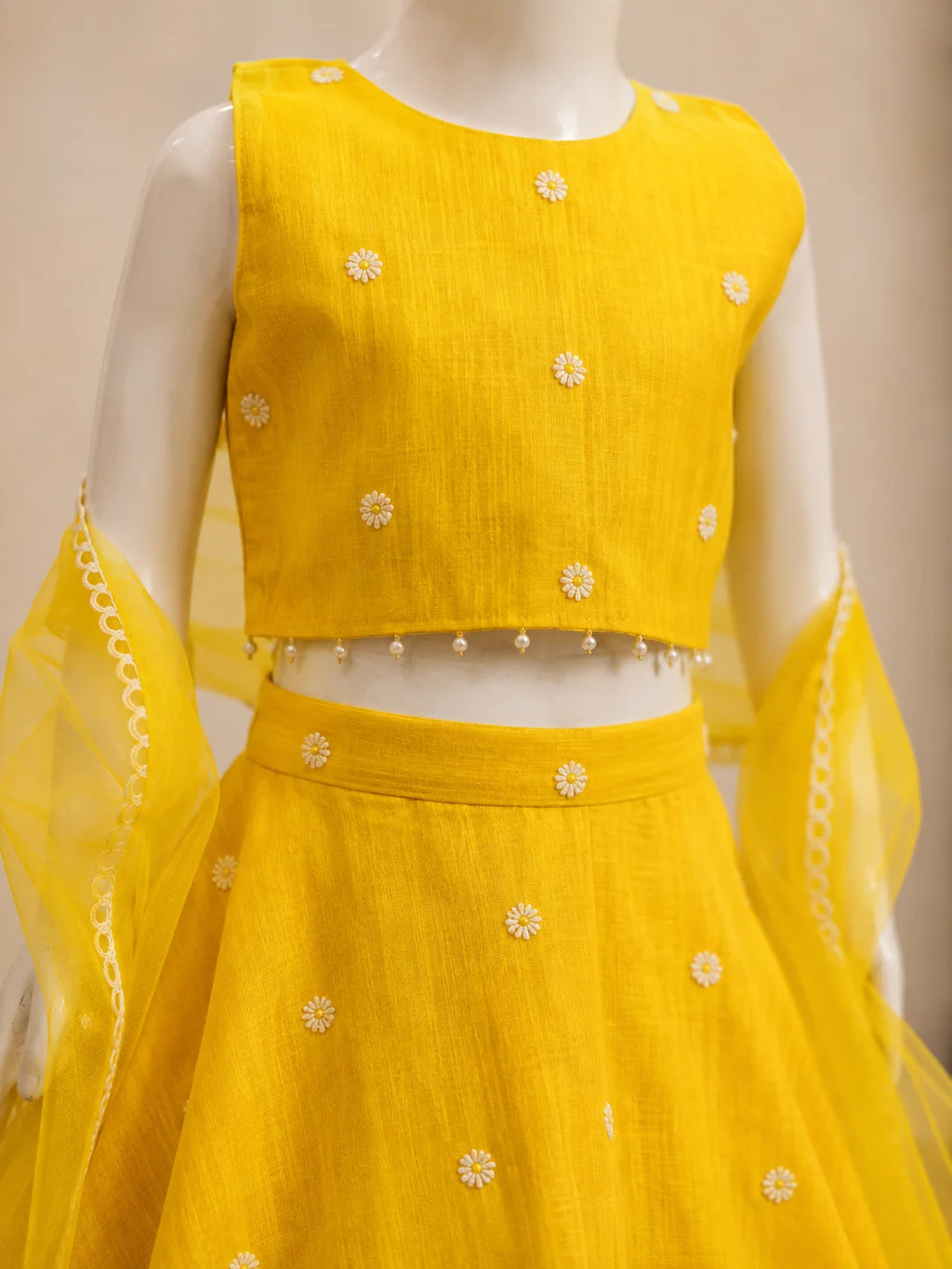 Yellow floral girls lehenga choli set with dupatta and pearl tassel detailing