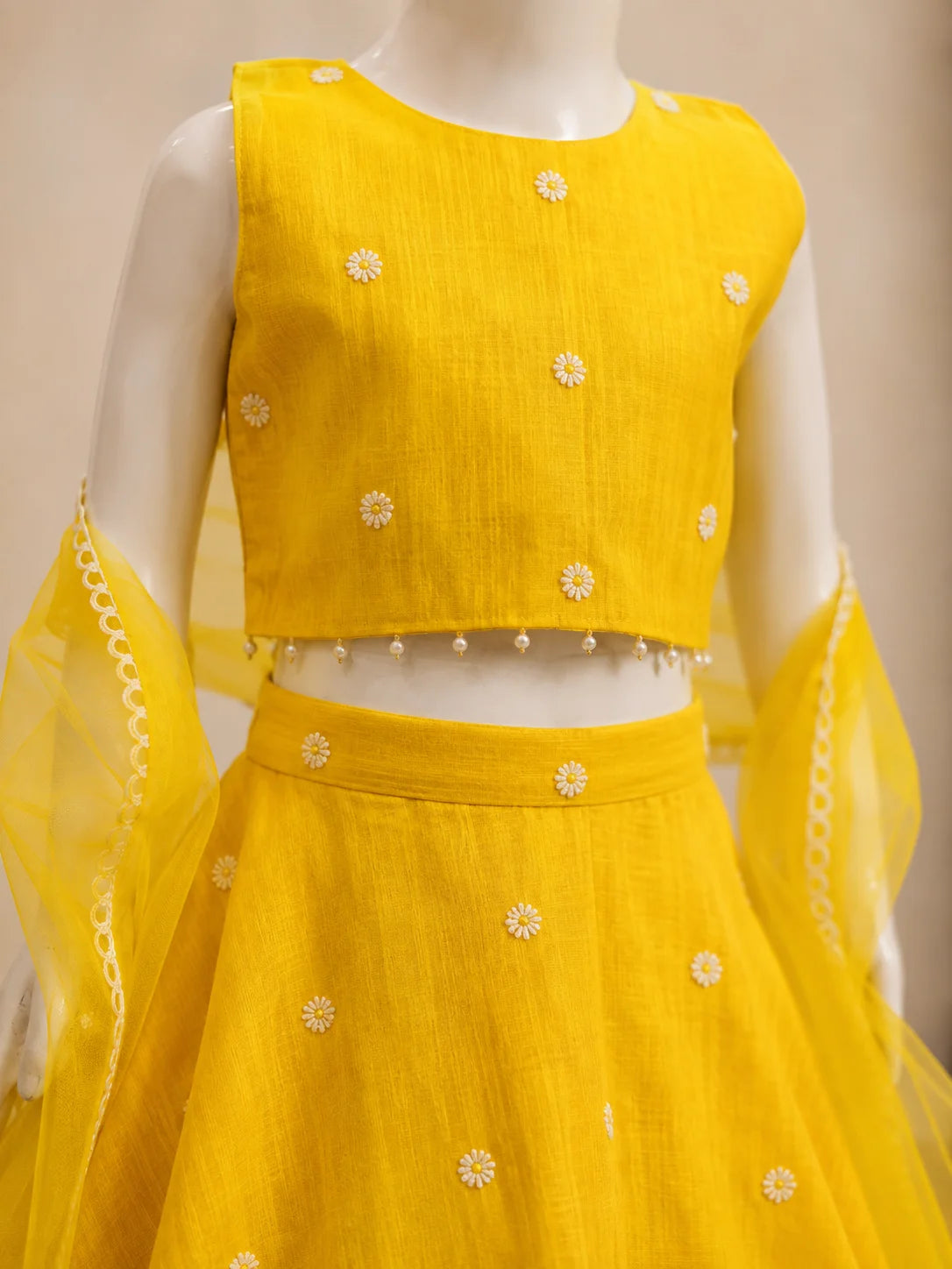 Yellow floral girls lehenga choli set with dupatta and pearl tassel detailing