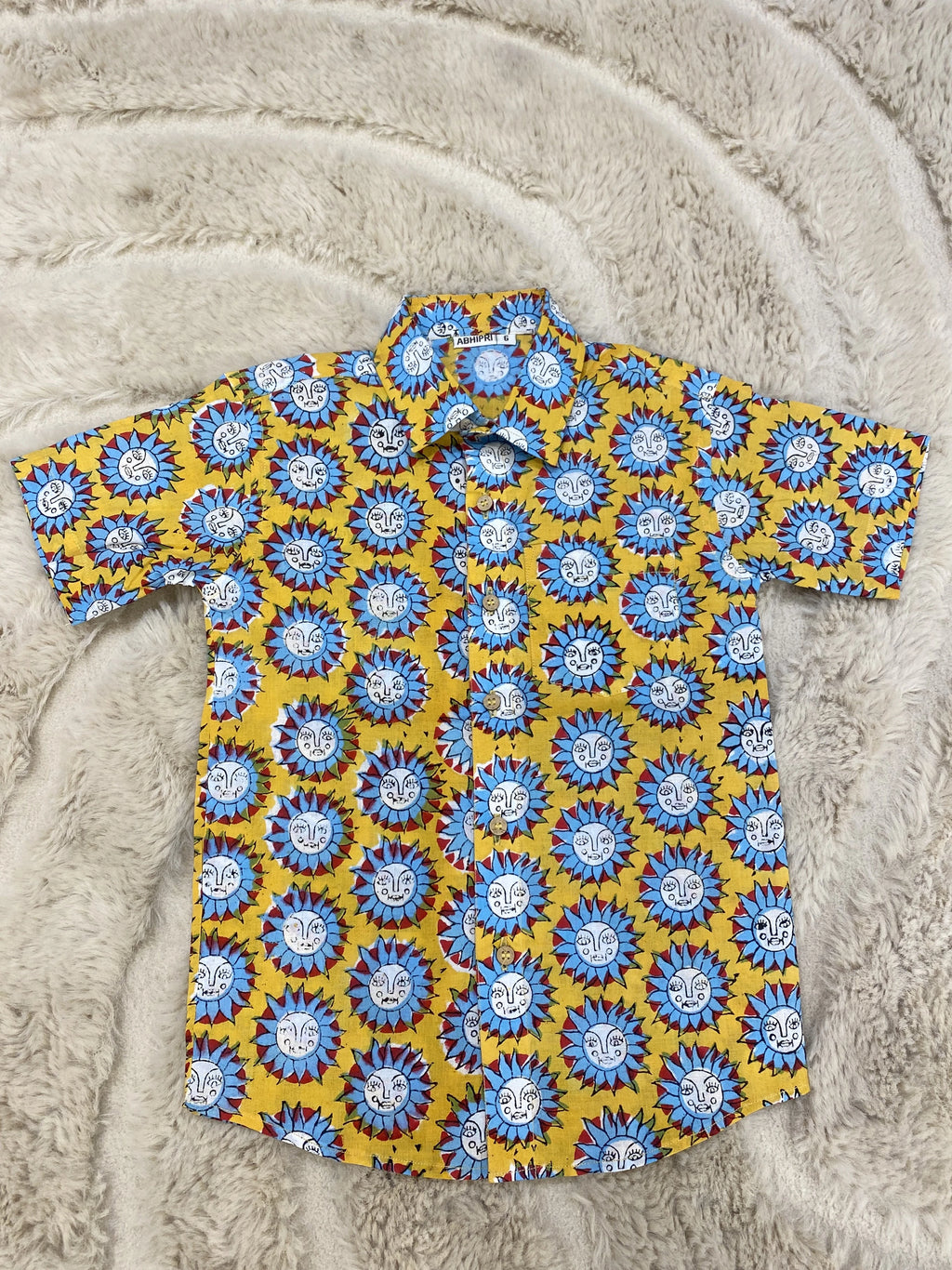 Boy wearing mustard yellow Surya motif printed half sleeve shirt with ivory trousers